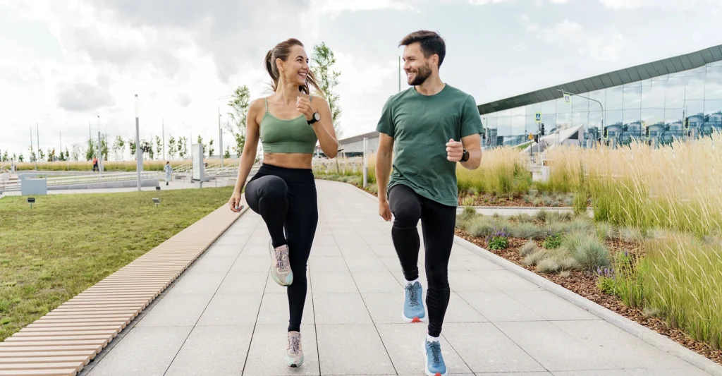 fit-couple-performs-dynamic-warmup-exercises-modern-park-smiling-enjoying-activity